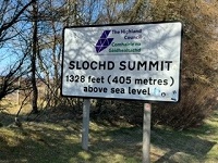 photo of a road sign to a summit ofn Slochd