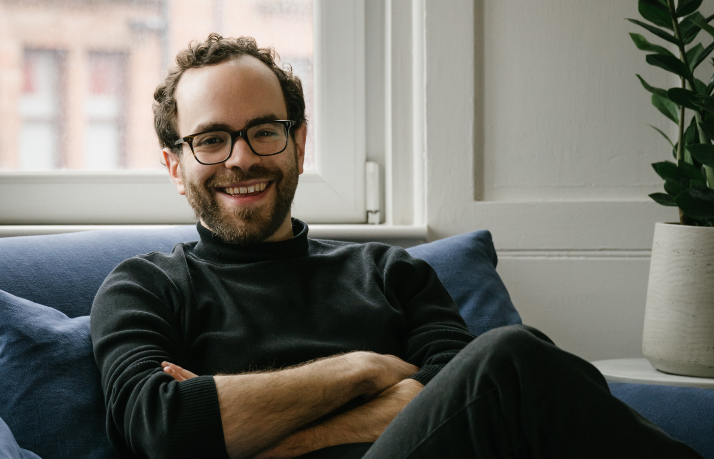 Ben Marvis sitting on a sofa smiling