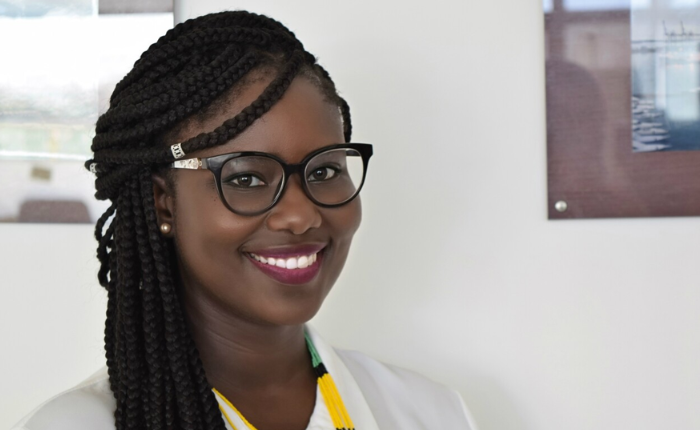 A woman in glasses smiles widely at the camera