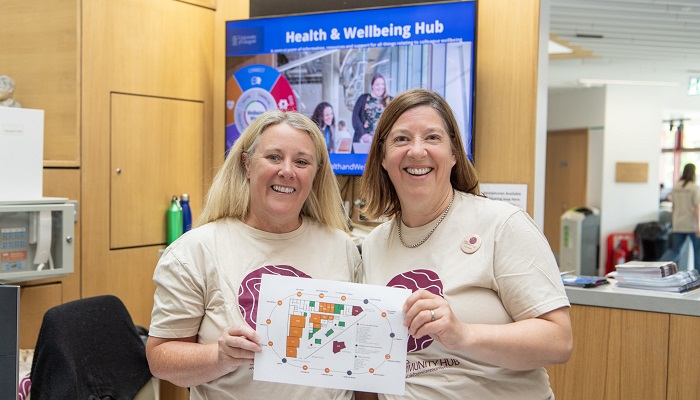 Two reception volunteers holding the Byres Community Hub Day Map 2024
