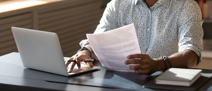 Photo of person in patterned shirt using laptop