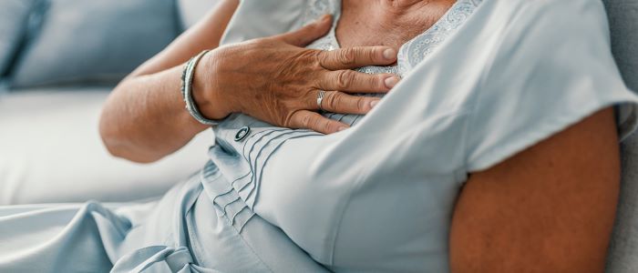 Photo of woman experiencing chest or heart pain