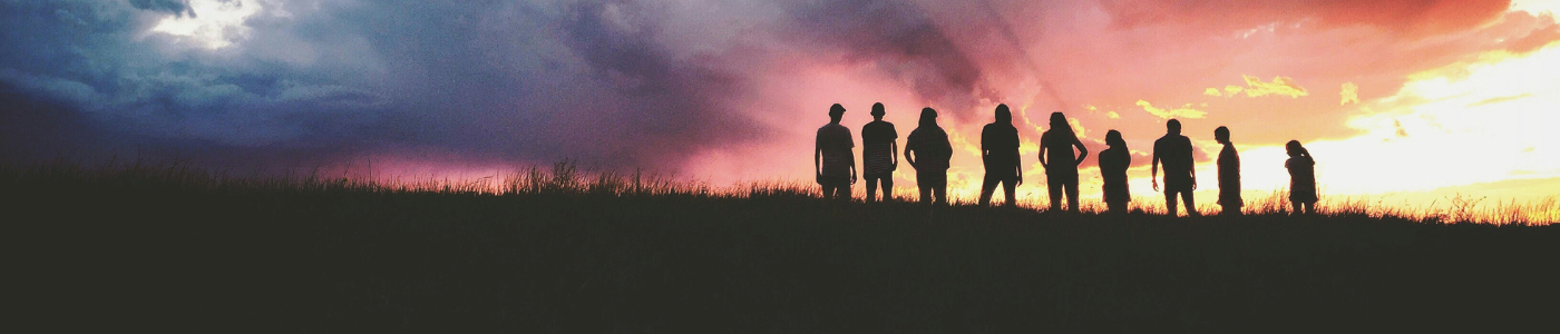 A group of people watching the sunset on the horizon