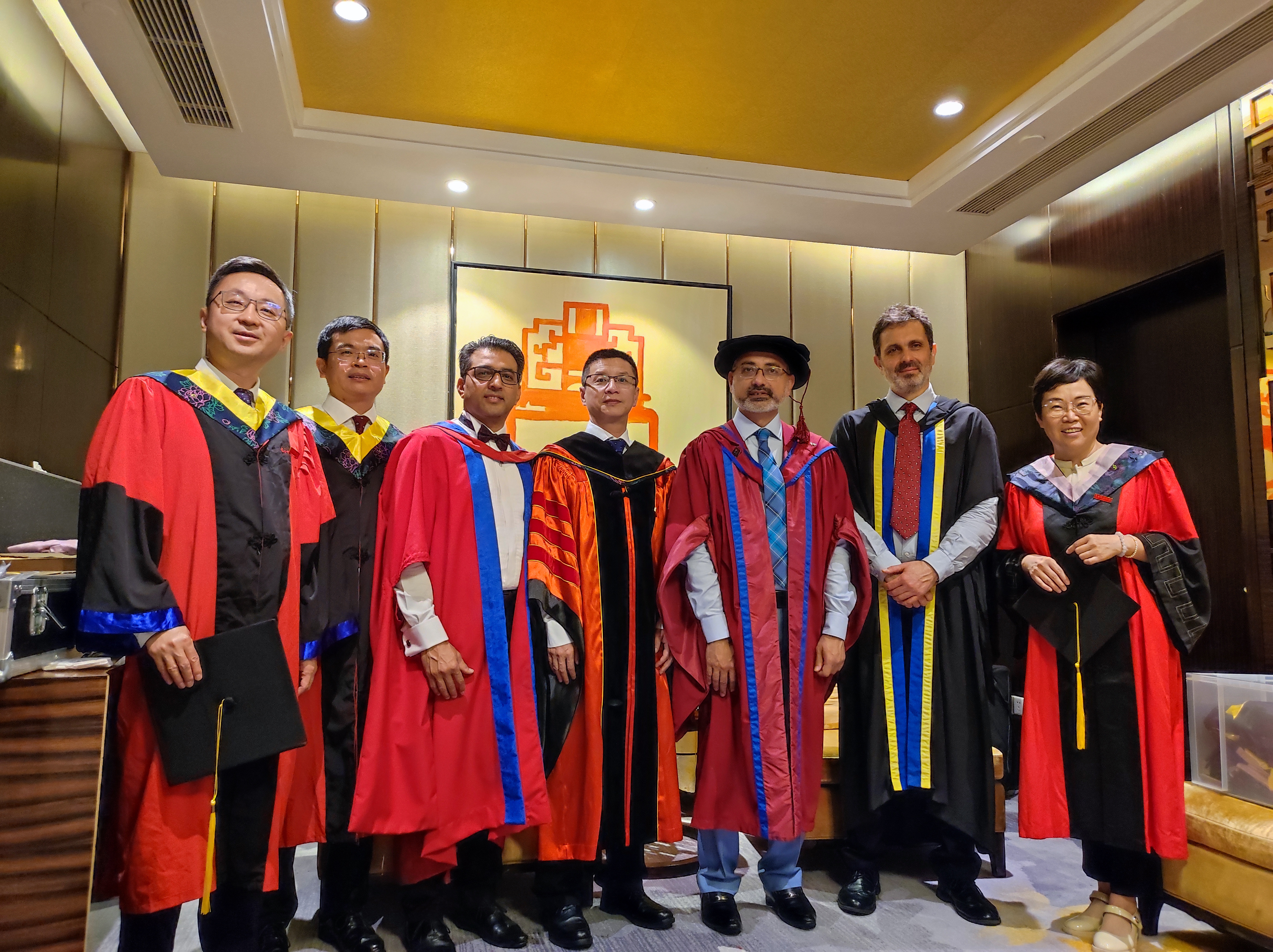 Staff from UESTC and UofG stand together in graduation gowns