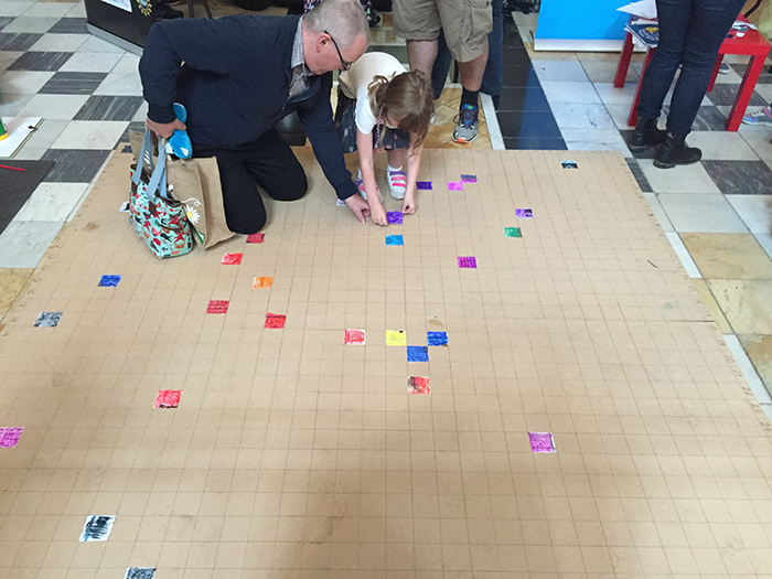 Visitors making a 'Gravitational Waves' giant collage