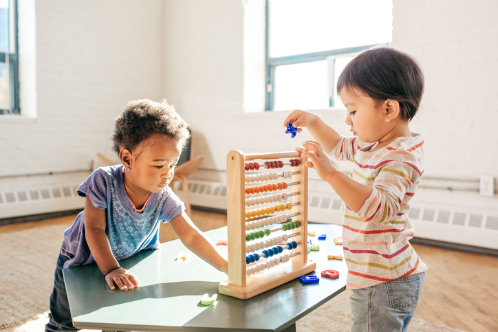 Two children playing with a abacus, 724x483px