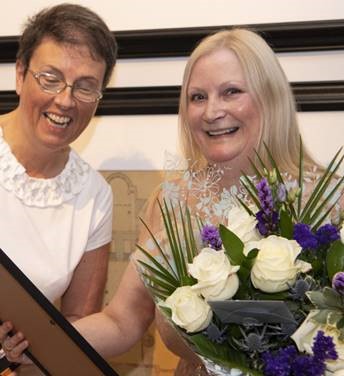 Photo of Professor Anna Cooper being presented with flowers by Professor Jill Pell on the occasion of her retirement