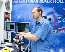 Photograph os a man in front of computers modelling how gravitational waves are detected. 