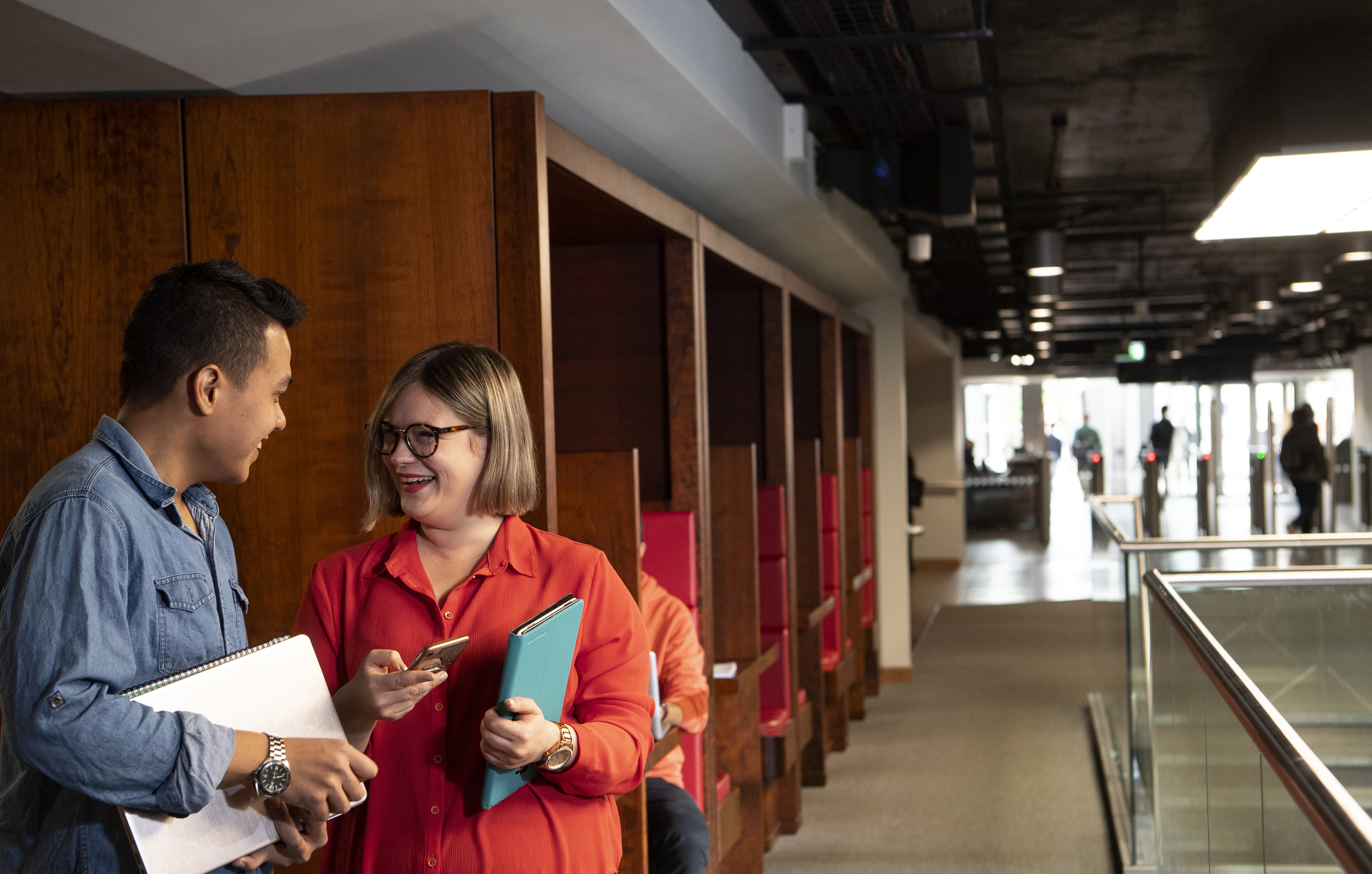 Two students standing in the library