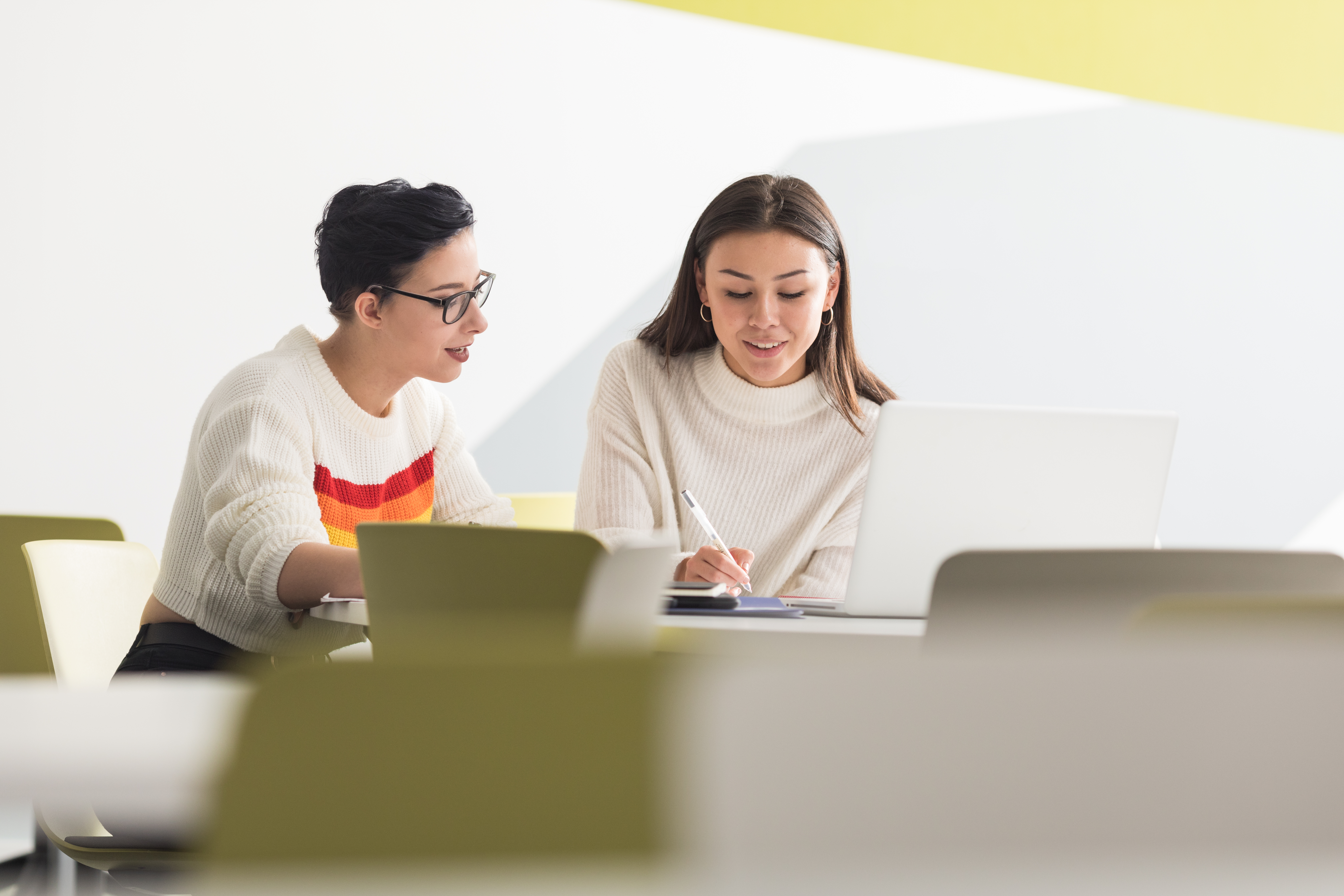 Two students sitting at a table in a lecture