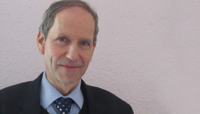 A head and shoulders shot of Professor Peter Kennedy wearing a shirt and tie 