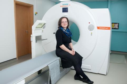 Portrait of Heather Williams infront of a PET scanner