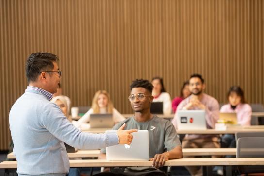 Lecturer standing in front of a room with students 