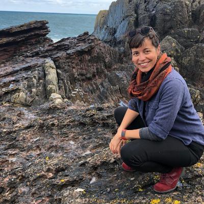 Woman kneeling in front of Siccar Point