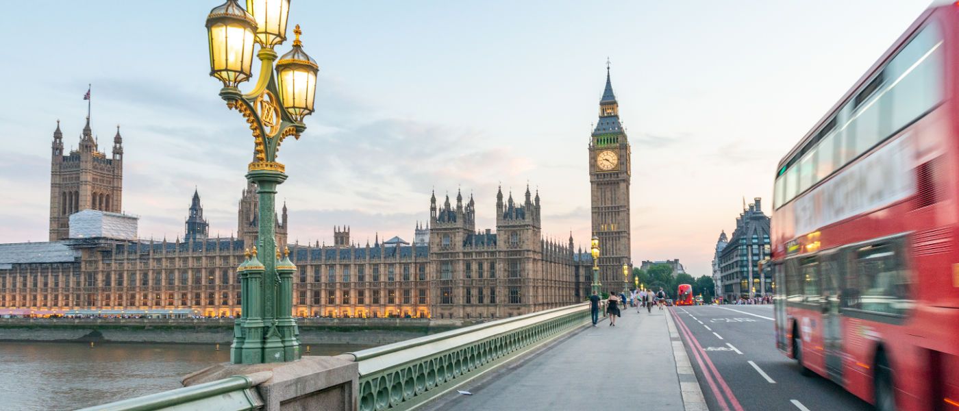 Big Ben and the Houses of Parliament viewed from Westminster Bridge with a red double decker whizzing past